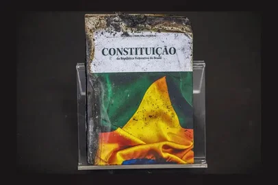 Brasília 04/02/2025- Foto feita em 07/02/2023 - Memorial com imagens e objetos destruídos do STF é montado na entrada do plenário. Entre os itens expostos, há a Constituição queimada (Foto), pedras portuguesas e bolas de gude usadas na destruição das vidraças, vidros estilhaçados e um vaso histórico português quebrado. 'Eles não conseguiram destruir o espírito da democracia’', disse Rosa Weber ao abrir a sessão'. Foto: Joédson Alves/Agência Brasil