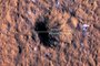 This handout image courtesy of NASA/JPL-Caltech/University of Arizona obtained on October 27, 2022 shows the impact crater, formed on  December 24, 2021, by a meteoroid strike in the Amazonis Planitia region of Mars, is about 490 feet (150 meters) across, as seen in this annotated image taken by the High-Resolution Imaging Science Experiment (HiRISE camera) aboard NASA's Mars Reconnaissance Orbiter. - Scientists passionate about Mars received a remarkable Christmas present last year. On December 24, 2021, a meteorite hit the Red Planet, causing magnitude 4 tremors, Nasa announced on October 27, 2022. The impact was detected by the Insight spacecraft and its seismometer, located some 3,500 kilometers away -- a position occupied since its landing on Mars almost four years ago. (Photo by NASA/JPL-Caltech/University of Arizona / AFP) / RESTRICTED TO EDITORIAL USE - MANDATORY CREDIT "AFP PHOTO / NASA/JPL-Caltech/University of Arizona" - NO MARKETING NO ADVERTISING CAMPAIGNS - DISTRIBUTED AS A SERVICE TO CLIENTS<!-- NICAID(15248375) -->