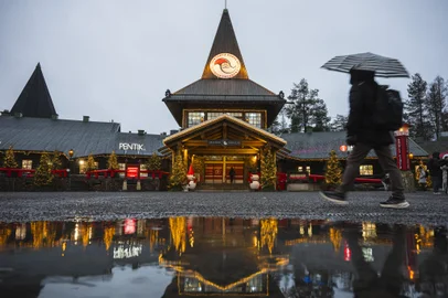 Tourists visit the Santa Claus Village during a rainy day, on November 16, 2024, near Rovaniemi, Finnish Lapland. With a month to go until Christmas, Santa Claus is busy preparing, but the warming climate and lack of snow in his Arctic hometown have him worried.By this time of year, the town of Rovaniemi in Finnish Lapland -- marketed by tourism officials since the 1980s as the "real" home of Santa Claus -- should be white and pretty. (Photo by Jonathan NACKSTRAND / AFP)Editoria: ACELocal: RovaniemiIndexador: JONATHAN NACKSTRANDSecao: customs and traditionFonte: AFPFotógrafo: STR<!-- NICAID(15921796) -->