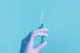 Syringe for injection in hand, latex medical gloves on hand. On a blue background.Seringa, luva, injeção, mão. Foto:  Snejana / stock.adobe.comFonte: 408254657<!-- NICAID(14840403) -->