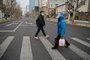 A woman wearing a face shield and mask amid the Covid-19 pandemic walks on a street in the Jing'an district in shanghai on January 9, 2023 (Photo by Hector RETAMAL / AFP)<!-- NICAID(15321787) -->