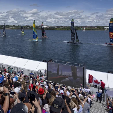 Spectators in the grandstand watch as the fleet led by Los Gallos SailGP Team ahead of Black Foils SailGP Team race past on Race Day 2 of the Canada Sail Grand Prix in Halifax, Canada. Sunday 21 June 2026. Rolex SailGP Championship Event 7 2026 Season. Photo: Jed Jacobsohn for SailGP. Handout image supplied by SailGP<!-- NICAID(16333626) -->