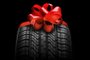 black isolation rubber tire, on the grey backgrounds in a bow for christmasFonte: 392817408<!-- NICAID(15619023) -->