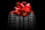 black isolation rubber tire, on the grey backgrounds in a bow for christmasFonte: 392817408<!-- NICAID(15619023) -->