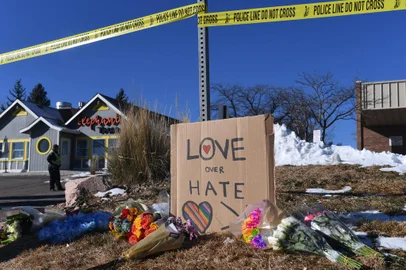 Bouquets of flowers and a sign reading "Love Over Hate" are left near Club Q, an LGBTQ nightclub in Colorado Springs, Colorado, on November 20, 2022. - At least five people were killed and 18 wounded in a mass shooting at an LGBTQ nightclub in the US city of Colorado Springs, police said on November 20, 2022. (Photo by Jason Connolly / AFP)<!-- NICAID(15270730) -->