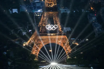 A photograph taken from an helicopter on July 26, 2024 shows an aerial view of the Eiffel Tower and the Olympics Rings lightened up during the opening ceremony of the Paris 2024 Olympic Games in Paris. (Photo by Lionel BONAVENTURE / POOL / AFP)Editoria: SPOLocal: ParisIndexador: LIONEL BONAVENTURESecao: sports eventFonte: POOLFotógrafo: STF<!-- NICAID(15824138) -->