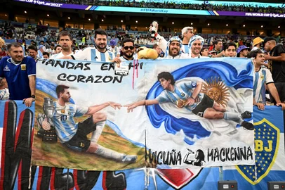 Argentina supporters display a banner depicting images of Argentina's forward #10 Lionel Messi and late Argentine football star Diego Maradona before the start of the Qatar 2022 World Cup quarter-final football match between The Netherlands and Argentina at Lusail Stadium, north of Doha on December 9, 2022. (Photo by MANAN VATSYAYANA / AFP)Editoria: SPOLocal: DohaIndexador: MANAN VATSYAYANASecao: soccerFonte: AFPFotógrafo: STF<!-- NICAID(15292874) -->