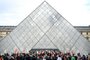 Employees hold banners and unions' flags as they block the entrance of the Musee du Louvre to denounce government's controversial pension reform, in Paris, on March 27, 2023. - A spokeswoman for the Parisian museum told AFP that this blocking of entries was carried out "by employees of the Louvre museum and other cultural sites". (Photo by Christophe ARCHAMBAULT / AFP)<!-- NICAID(15386673) -->