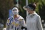 A woman (L) wearing a face mask to shelter from the sun walks on a street during heatwave conditions in Beijing on July 19, 2023. (Photo by Jade Gao / AFP)Editoria: WEALocal: BeijingIndexador: JADE GAOSecao: reportFonte: AFPFotógrafo: STF<!-- NICAID(15489206) -->