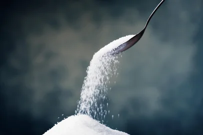 Adding sugar with a spoon.Fonte: 2306955<!-- NICAID(15852715) -->