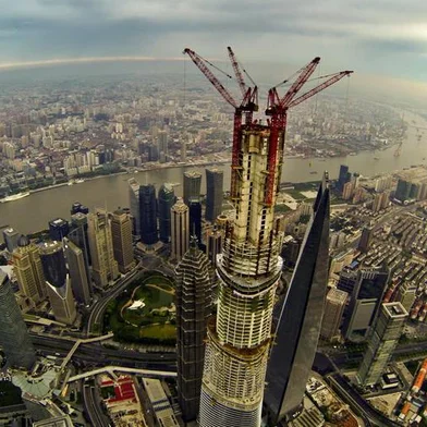 This picture taken on August 4, 2013 shows a general view of the under-construction Shanghai Tower (C) and the 492m Shanghai World Financial Center (R), the 421m Jin Mao Tower (L) in Shanghai. Work on the main structure of the world's second tallest skyscraper was completed on August 3 as a crane placed a steel beam 580 meters (1,900 feet) above the ground, as the building formally overtook Taiwan's 509 meter tall Taipei 101 building to become the tallest tower in Asia. CHINA OUT     AFP PHOTO