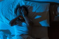 Beautiful girl suffering from insomnia lying in her bed in the middle of the night. Hands in her face. High quality photo<!-- NICAID(16343360) -->