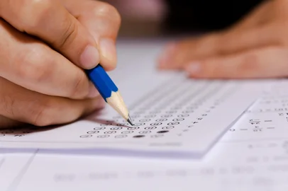 Students hand holding pencil writing selected choice on answer sheets and Mathematics question sheets. students testing doing examination. school exam Indexador: Tevarak PhanduangFonte: 296838651<!-- NICAID(16337876) -->