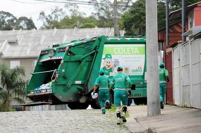 CAXIAS DO SUL, RS, BRASIL, 28/10/2016. Os coletores da Companhia de Desenvolvimento de Caxias do Sul (Codeca) estão enfrentando verdadeiras maratonas para recolher lixo nas ruas da cidade. Desde quinta-feira, o Ministério do Trabalho e Emprego (MTE) proibiu o transporte dos trabalhadores no estribo do caminhão, que fica na parte traseira junto ao compactador de resíduos. Por esse motivo, eles percorrem o roteiro a pé. Em alguns casos, o trajeto chega a 30 quilômetros. Recolhimento de lixo no bairro Desvio Rizzo. Na foto da E p/ D: Roque Silveira, 30, Luis Carlos Welter, 37 e Luiz Carlos Palhano dos Santos, 49. (Porthus Junior/Pioneiro)<!-- NICAID(12532183) -->