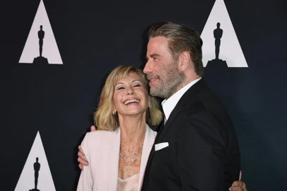 (FILES) In this file photo taken on August 15, 2018 actors Olivia Newton-John and John Travolta pose on the red carpet as they arrive for the 40th anniversary celebration of the movie "Grease" at the Academy of Motion Picture Arts and Sciences (AMPAS) in Beverly Hills, California. - Australian singer Olivia Newton-John, who gained worldwide fame as high-school sweetheart Sandy in the hit musical movie "Grease," died on August 8, 2022, her family said. She was 73. The entertainer, whose career spanned more than five decades, devoted much of her time and celebrity to charities after being diagnosed with breast cancer in 1992. (Photo by Mark RALSTON / AFP)<!-- NICAID(15169890) -->