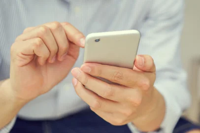 close up hand hold mobile cell phone device:focus on man play on smartphone conceptFonte: 288294879<!-- NICAID(14747462) -->