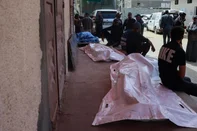 Relatives gather near the bodies of three Palestinian men who were killed in an Israeli drone strike east of the Bureij camp, at the al-Aqsa Martyrs hospital in Deir el-Balah in the central Gaza Strip on March 17, 2025. (Photo by Eyad BABA / AFP)<!-- NICAID(15997743) -->