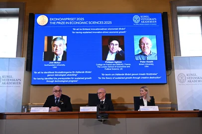 Secretary General of The Royal Swedish Academy of Sciences Hans Ellegren (C) addresses journalists flanked by Members of the Economics Nobel Prize committee (L) and Kerstin Enflo during the announcement of the winner of the 2025 Nobel Prize in Economics, the Sveriges Riksbank Prize in Economic Sciences in Memory of Alfred Nobel, at the Royal Swedish Academy of Sciences in Stockholm, Sweden, on October 13, 2025. The Royal Swedish Academy of Sciences has decided to award the Sveriges Riksbank Prize in Economic Sciences in Memory of Alfred Nobel 2025 to Joel Mokyr, Philippe Aghion and Peter Howitt for having explained innovation-driven economic growth with one half to Joel Mokyr for having identified the prerequisites for sustained growth through technological progress and the other half jointly to Philippe Aghion and Peter Howitt for the theory of sustained growth through creative destruction. (Photo by Jonathan Nackstrand / AFP)<!-- NICAID(16144640) -->