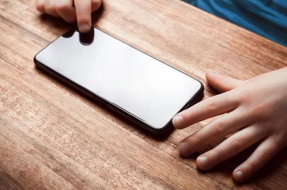 Child Playing With Smartphone On A Table - Prevent Child Smartphone Addiction ConceptPORTO ALEGRE, RS,  BRASIL, 14-08-2025: Conceito de criança no celular. Foto: devenorr/stock.adobe.comIndexador: DevenorrFonte: 430659629<!-- NICAID(16101709) -->
