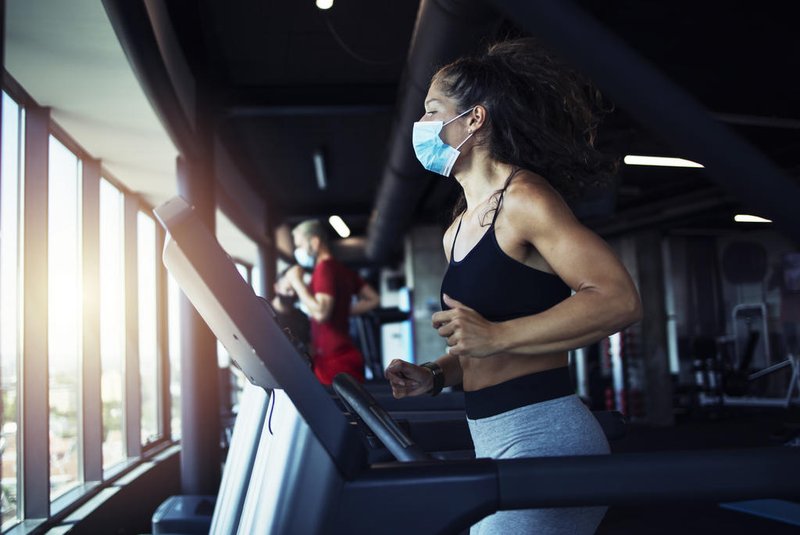 Active fitness woman wearing hygienic protective face mask while training in gym to protect herself and others against coronavirus or covid-19. Stay safe and healthy.Fonte: 367015334<!-- NICAID(14646772) -->