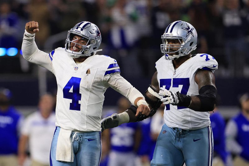 ARLINGTON, TEXAS - NOVEMBER 30: Quarterback Dak Prescott #4 of the Dallas Cowboys celebrates with offensive tackle Tyron Smith #77 after throwing for a touchdown during the 4th quarter of the game against the Seattle Seahawks at AT&T Stadium on November 30, 2023 in Arlington, Texas.   Ron Jenkins/Getty Images/AFP (Photo by Ron Jenkins / GETTY IMAGES NORTH AMERICA / Getty Images via AFP)<!-- NICAID(15613965) -->