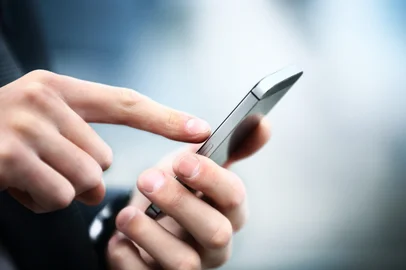 Close up of a man using mobile smart phone<!-- NICAID(15997542) -->