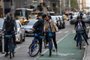 People biking down a road kiss in Manhattan, New York on April 27, 2021. - Americans vaccinated against Covid-19 no longer need to mask up outdoors when there is no crowd, President Joe Biden said, before celebrating by taking his first short walk at the White House without the face covering. (Photo by Angela Weiss / AFP)<!-- NICAID(14770273) -->