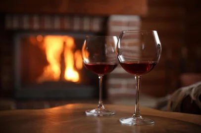 Adobe Stock - VinhoGlasses of wine blurred fireplace on background, space for text. Winter vacationFonte: 348356576<!-- NICAID(16066117) -->