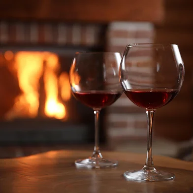 Adobe Stock - VinhoGlasses of wine blurred fireplace on background, space for text. Winter vacationFonte: 348356576<!-- NICAID(16066117) -->