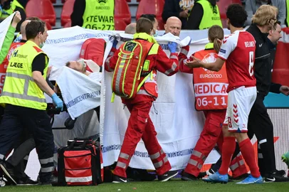 Medics stretcher Denmark's midfielder Christian Eriksen off the pitch after he collapsed during the UEFA EURO 2020 Group B football match between Denmark and Finland at the Parken Stadium in Copenhagen on June 12, 2021. (Photo by Jonathan NACKSTRAND / POOL / AFP)<!-- NICAID(14807665) -->