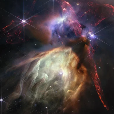 The first anniversary image from NASA’s James Webb Space Telescope displays star birth like it’s never been seen before, full of detailed, impressionistic texture. The subject is the Rho Ophiuchi cloud complex, the closest star-forming region to Earth. It is a relatively small, quiet stellar nursery, but you’d never know it from Webb’s chaotic close-up. Jets bursting from young stars crisscross the image, impacting the surrounding interstellar gas and lighting up molecular hydrogen, shown in red. Some stars display the telltale shadow of a circumstellar disk, the makings of future planetary systems.<!-- NICAID(15480079) -->