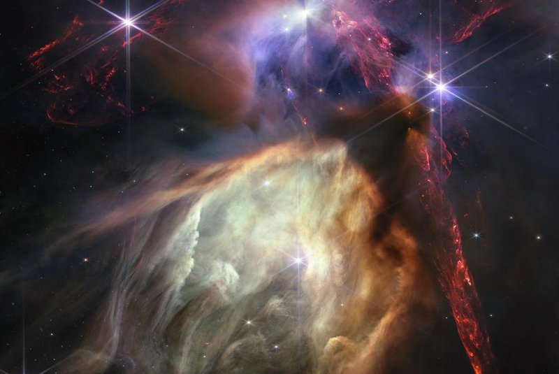 The first anniversary image from NASA’s James Webb Space Telescope displays star birth like it’s never been seen before, full of detailed, impressionistic texture. The subject is the Rho Ophiuchi cloud complex, the closest star-forming region to Earth. It is a relatively small, quiet stellar nursery, but you’d never know it from Webb’s chaotic close-up. Jets bursting from young stars crisscross the image, impacting the surrounding interstellar gas and lighting up molecular hydrogen, shown in red. Some stars display the telltale shadow of a circumstellar disk, the makings of future planetary systems.<!-- NICAID(15480079) -->