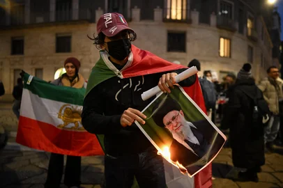An Anti-Iranian regime protester burns a photo depicting Ali Khamenei, Supreme Leader of Iran, during a gathering outside the US Consulate in Milan, on January 13, 2026 (Photo by Piero CRUCIATTI / AFP)<!-- NICAID(16203757) -->