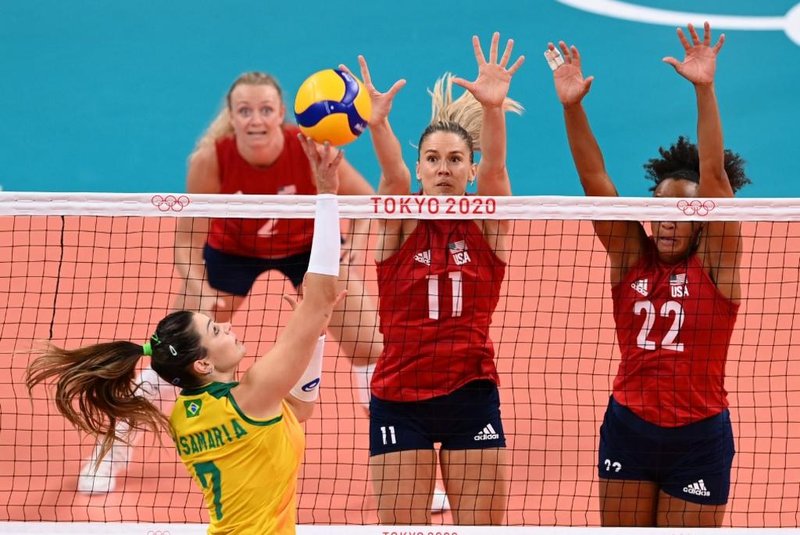Brazil's Rosamaria Montibeller (L) hits the ball as USA's Andrea Drews (C) and USA's Haleigh Washington (R) attempt to block it in the women's gold medal volleyball match between Brazil and USA during the Tokyo 2020 Olympic Games at Ariake Arena in Tokyo on August 8, 2021. (Photo by JUNG Yeon-je / AFP)<!-- NICAID(14857164) -->