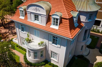 Um lindo casarão do bairro Moinhos de Vento, em Porto Alegre, ganhou vida nova. Após a conclusão das obras de restauro, a residência número 229 da Rua Santo Inácio virou sede da Woss Incorporadora. O prédio foi projetado nos anos 1920 por um arquiteto alemão, ferido em guerra e que veio ao Brasil após desilusão amorosa. O arquiteto Karl Adolph Heinrich Siegert (1889-1961) chegou a Porto Alegre em 1923. Filho de professor da faculdade de arquitetura, ele ficou gravemente ferido durante a 1ª Guerra Mundial. Depois de longo período de hospitalização, se separou da esposa. O desiludido alemão decidiu emigrar.Durante a viagem ao Brasil, no navio, conheceu o comerciante Carlos Barth Jr., proprietário da famosa loja A Brasileira, que o contratou para construção de casa no Moinhos de Vento. Em 23 de novembro de 1926, foi assinada a planta da mansão de três andares.  <!-- NICAID(16036646) -->