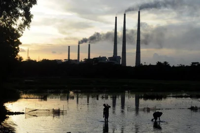 In this file photo taken on July 26, 2011, Indian labourers prepare the flooded field for rice farming near Kolaghat Thermal Power Plant in Mecheda, around 85 kms south-west of Kolkata. - Global efforts to arrest climate change and keep Earth liveable will fail without a jumbo-sized effort from India that experts say will need political will and an ocean of outside money. (Photo by Dibyangshu SARKAR / AFP)<!-- NICAID(14762121) -->