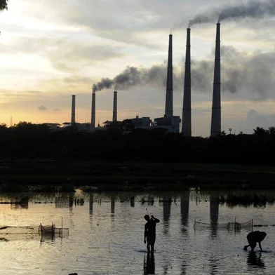 In this file photo taken on July 26, 2011, Indian labourers prepare the flooded field for rice farming near Kolaghat Thermal Power Plant in Mecheda, around 85 kms south-west of Kolkata. - Global efforts to arrest climate change and keep Earth liveable will fail without a jumbo-sized effort from India that experts say will need political will and an ocean of outside money. (Photo by Dibyangshu SARKAR / AFP)<!-- NICAID(14762121) -->