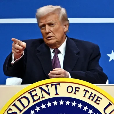 US President Donald Trump gestures as he attends the inaugural parade inside Capital One Arena, in Washington, DC, on January 20, 2025. (Photo by ANGELA WEISS / AFP)<!-- NICAID(15957827) -->
