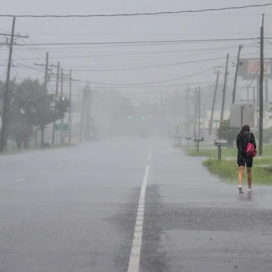 HOUMA, LOUISIANA - SEPTEMBER 11: A person walks through a downpour as Hurricane Francine hits the area on September 11, 2024 in Houma, Louisiana. Hurricane Francine maintains its Category 1 classification and is projected to make landfall along the Louisiana coast later this afternoon. Weather analysts are predicting 90mph winds near the eye and a strong storm surge along the coast.   Brandon Bell/Getty Images/AFP (Photo by Brandon Bell / GETTY IMAGES NORTH AMERICA / Getty Images via AFP)<!-- NICAID(15864253) -->
