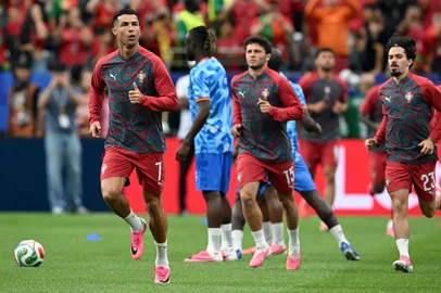 Portugal's forward #07 Cristiano Ronaldo (L), Portugal's midfielder #15 Joao Neves (C) and Portugal's midfielder #23 Vitinha warm up ahead of the 2026 World Cup Group K football match between Portugal and the Democratic Republic of Congo at the Houston Stadium in Houston on June 17, 2026.  (Photo by RONALDO SCHEMIDT / AFP)<!-- NICAID(16308424) -->