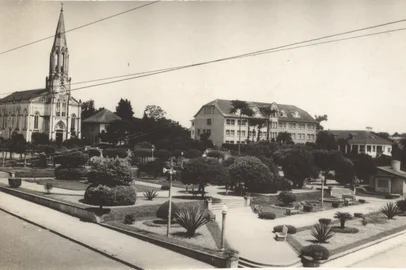 CanoasPraça da Bandeira, aos fundos a Igreja Matriz São Luiz Gonzaga e Colégio Maria Auxiliadora. (circa 1970)<!-- NICAID(16323163) -->