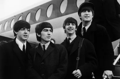 FILE - Tale Of Two Apples Said To Merge In Online DealLONDON - FEBRUARY 8, 1964:  (FILE) (L-R) Paul McCartney, George Harrison, Ringo Starr and John Lennon of the British pop group The Beatles are shown at London Airport February 8, 1964 in London, England.  Fortune magazine reported November 27, 2006 that the Fab Four and Apple Computer were close to a deal that would make the group's extensive library of rock classics available exclusively for a limited time on the computer company's iTunes Store website.  (Photo by Getty Images) *** Local Caption *** Paul McCartney;George Harrison;Ringo Starr;John LennonEditoria: ACELocal: LondonIndexador: Evening StandardFonte: Getty Images North AmericaFotógrafo: Stringer<!-- NICAID(14472665) -->