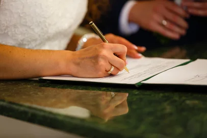 The bride writes with a pen, Closeup of woman's hand writing on paperThe bride writes with a pen, Closeup of woman's hand writing on paperIndexador: Andrey SinenkiyFonte: 167147000<!-- NICAID(16187912) -->