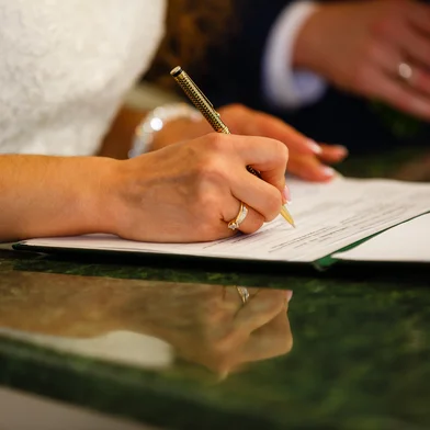 The bride writes with a pen, Closeup of woman's hand writing on paperThe bride writes with a pen, Closeup of woman's hand writing on paperIndexador: Andrey SinenkiyFonte: 167147000<!-- NICAID(16187912) -->