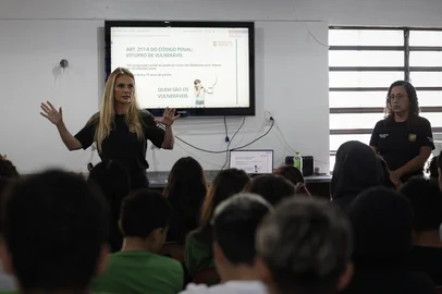 PORTO ALEGRE, RS, BRASIL, 26-02-2026: As policiais civis Bianca Benemann e Débora Prestes durante palestra do Programa Libertar para estudantes de diversas turmas na Escola Estadual de Ensino Fundamental Brasília, no bairro São João. A iniciativa, criada pela escrivã Bianca, atua nas escolas para prevenir e combater crimes sexuais contra crianças e adolescentes. O projeto realiza palestras educativas e acolhimento imediato de vítimas, facilitando denúncias e o início de investigações, rompendo o ciclo de violência. Foto: Mateus Bruxel/Agência RBSIndexador: MATEUS BRUXEL<!-- NICAID(16233385) -->