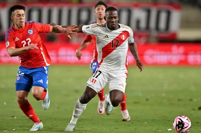 Chile's forward #22 Alexander Aravena AND Peru's defender #17 Luis Advincula fight for the ball during the 2026 FIFA World Cup South American qualifiers football match between Peru and Chile at the National stadium in Lima on November 15, 2024. (Photo by CRIS BOURONCLE / AFP)<!-- NICAID(15915133) -->