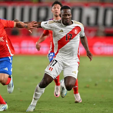 Chile's forward #22 Alexander Aravena AND Peru's defender #17 Luis Advincula fight for the ball during the 2026 FIFA World Cup South American qualifiers football match between Peru and Chile at the National stadium in Lima on November 15, 2024. (Photo by CRIS BOURONCLE / AFP)<!-- NICAID(15915133) -->