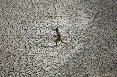A boy runs across a patch of parched riverbed of Yamuna on a hot summer day in New Delhi on May 2, 2022. (Photo by Sajjad HUSSAIN / AFP)Editoria: WEALocal: New DelhiIndexador: SAJJAD HUSSAINSecao: peopleFonte: AFPFotógrafo: STR<!-- NICAID(15085089) -->