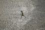 A boy runs across a patch of parched riverbed of Yamuna on a hot summer day in New Delhi on May 2, 2022. (Photo by Sajjad HUSSAIN / AFP)Editoria: WEALocal: New DelhiIndexador: SAJJAD HUSSAINSecao: peopleFonte: AFPFotógrafo: STR<!-- NICAID(15085089) -->
