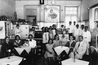 Bomboniére Maratá, de propriedade do casal Ordália da Silva e Abílio da Silva, em meados de 1943, quando reinaugurou. Na imagem aparecem Abílio da Silva (terno claro, sentado à direita), Ordália da Silva (ao lado dele, de vestiudo listado), Argélia Manfredini (irmã de Ordália, de óculos, sentada) e a menina Odelir Silva Nora (filha de Ordália e Abílio, de vestido poá). Atrás do balcão aparecem os meninos Élvio Francisco da Silva (à esquerda) e Guimarães Francisco da Silva (de óculos, ao lado da caixa registradora). Na mesa à esquerda, o gerente do café, sr. João, com sua família. Mais atrás, á direita, os garçons (a partir da frente) Cassiano, Clóvis, Osvaldo, um não identificado e Paraguai (chefe dos garçons, com a toalha no braço, próximo ao telefone). Local estava situado no térreo da família do alfaiate Rodolpho Braghirolli. Abriu em 1941 como bar, quando a família de Abílio e Ordália chegou de Montenegro e se estabeleceu na cidade. A Bomboniére reinaugurou em 1943 e funcionou até 1949.<!-- NICAID(11611399) -->